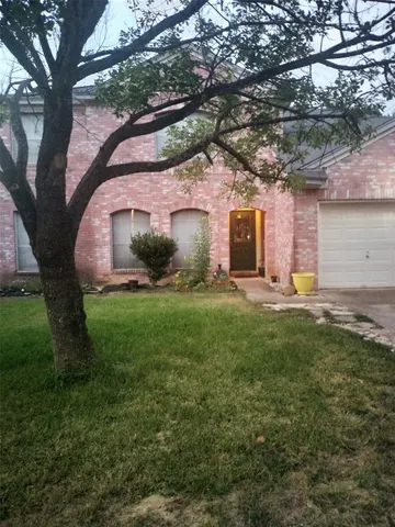 a front view of a house with a garden and yard