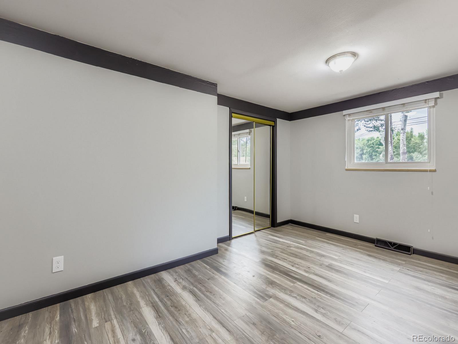 4292 North 119th Street Erie, CO 80516 - Photo 19 of 30 an empty room with wooden floor and windows