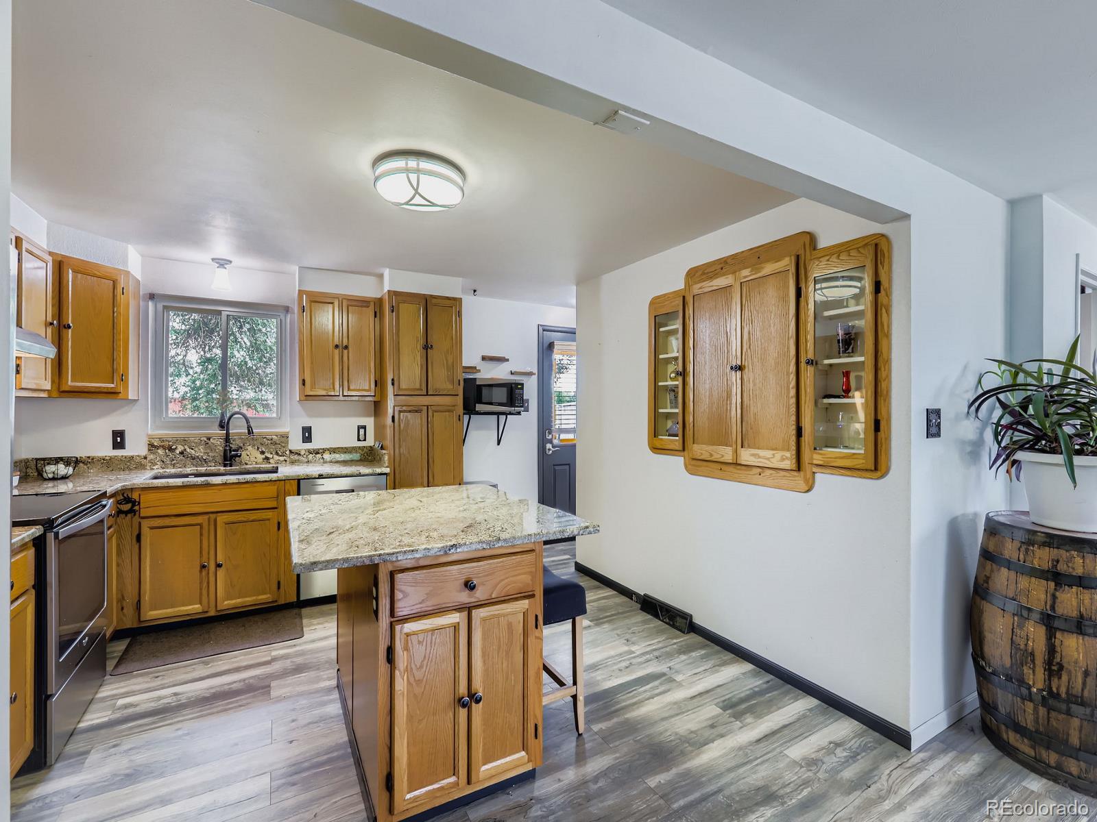 4292 North 119th Street Erie, CO 80516 - Photo 3 of 30 a kitchen with stainless steel appliances granite countertop wooden cabinets a stove a sink and a refrigerator