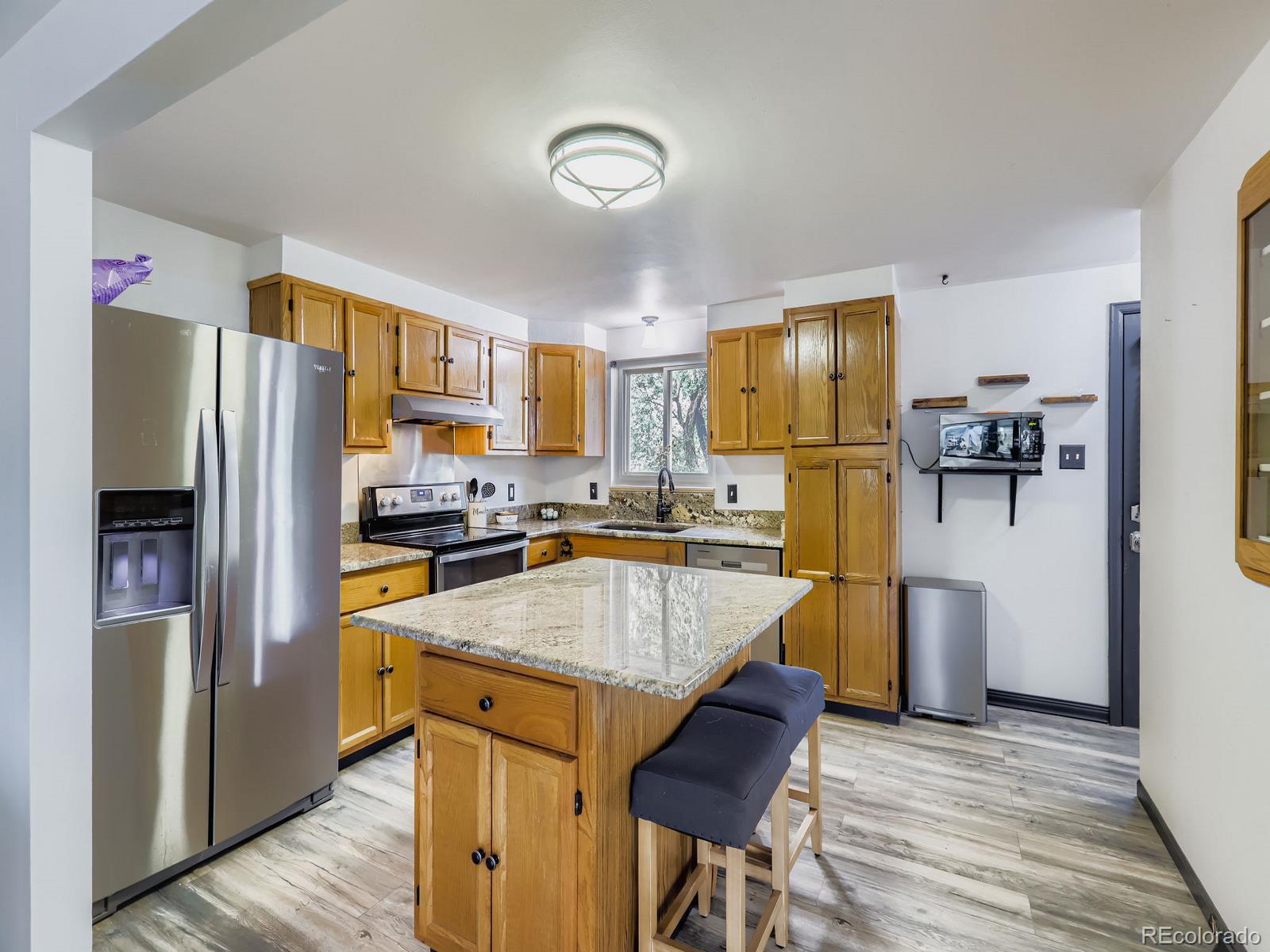 4292 North 119th Street Erie, CO 80516 - Photo 4 of 30 a kitchen with stainless steel appliances granite countertop a refrigerator and a stove top oven