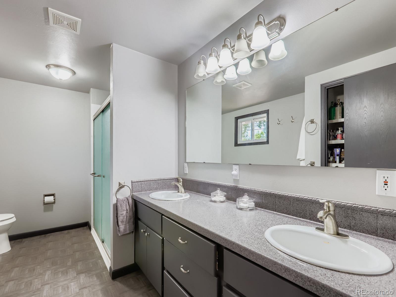 4292 North 119th Street Erie, CO 80516 - Photo 7 of 30 a bathroom with a granite countertop sink a large mirror and a light fixture