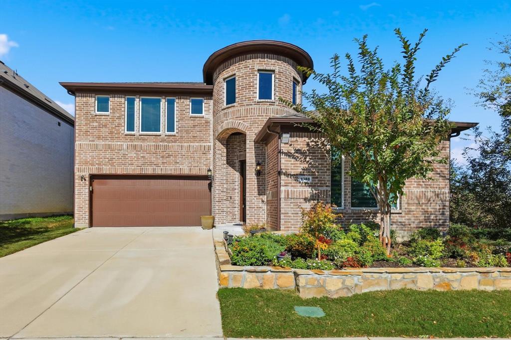 View of front of house featuring concrete driveway, brick siding, and a garage