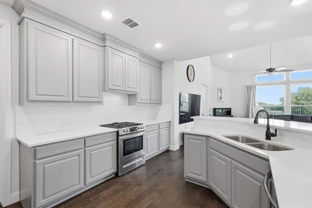 a kitchen with white cabinets stainless steel appliances and sink