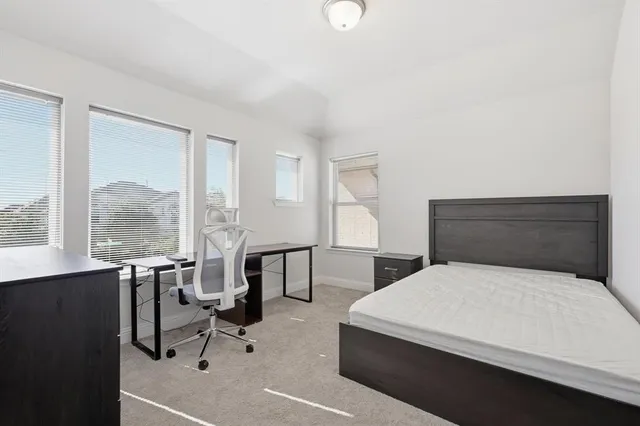 a bedroom with a bed and large windows