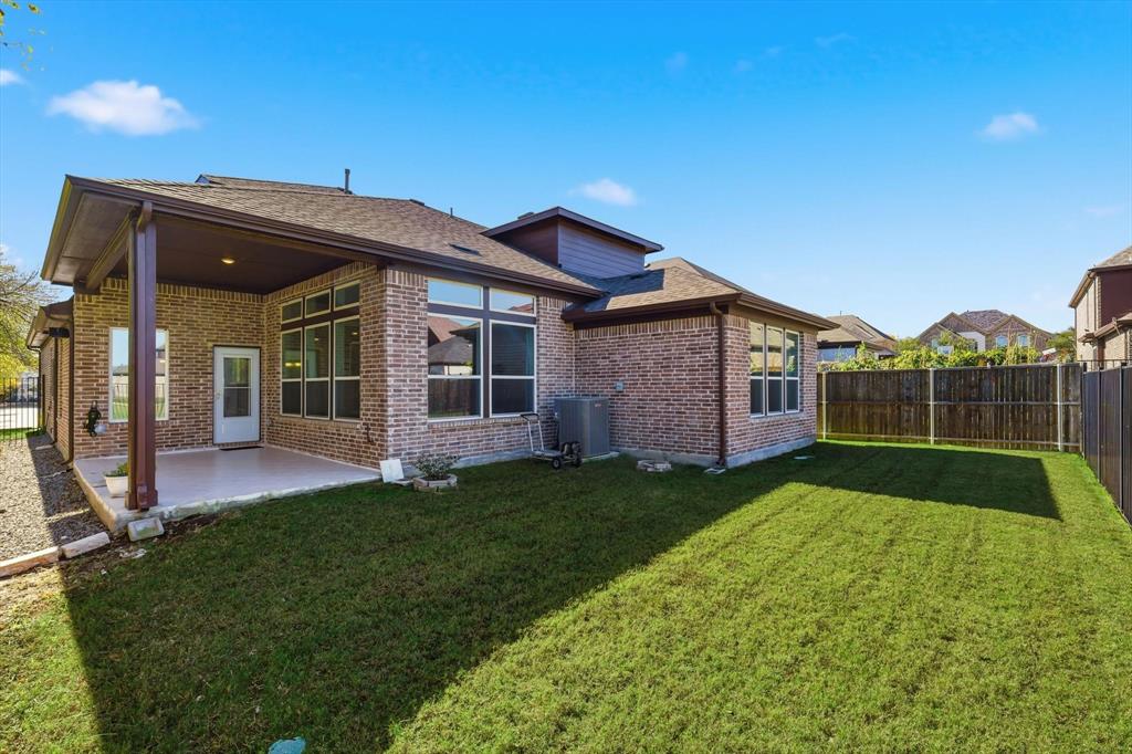 1988 Nottingham Place Allen, TX 75013 - Photo 35 of 40 Rear view of property with a fenced backyard, brick siding, a patio area, and roof with shingles