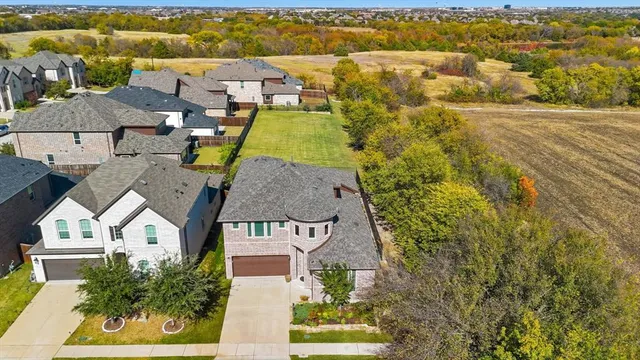 an aerial view of residential houses with yard
