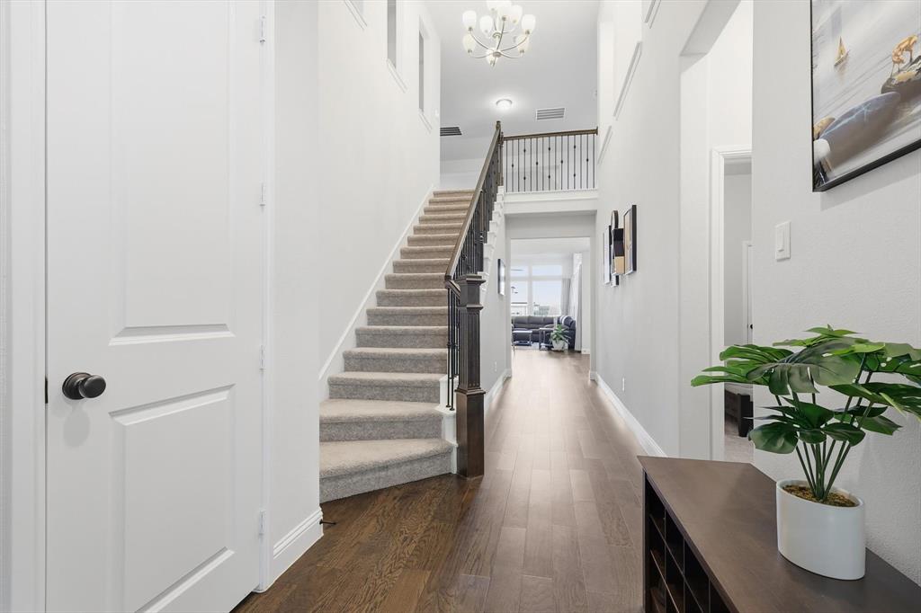 1988 Nottingham Place Allen, TX 75013 - Photo 5 of 40 Entryway featuring dark wood-style floors, a high ceiling, stairway, and a chandelier
