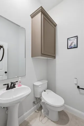 a bathroom with a toilet sink and mirror