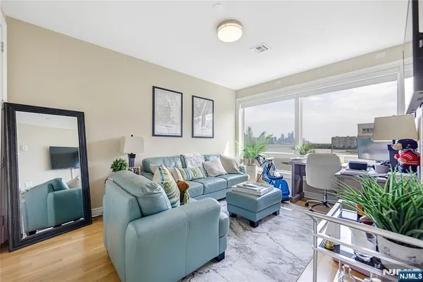 a living room with furniture potted plant and a large window