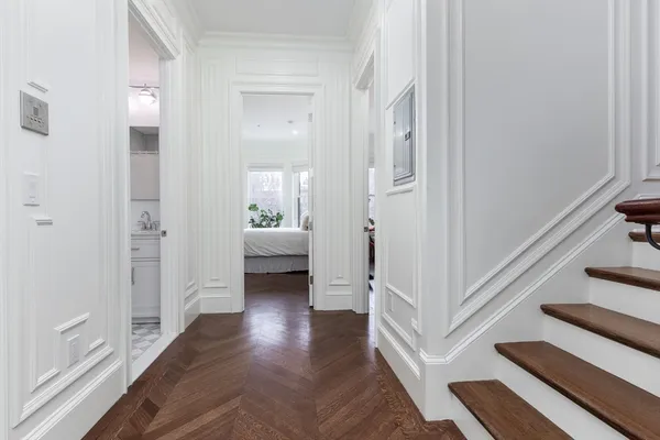 a view of a hallway with wooden floor and staircase