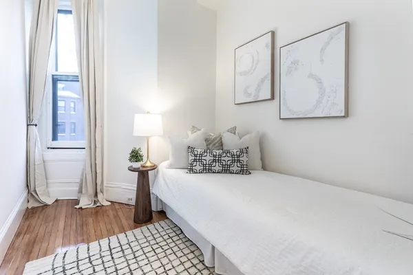 a spacious bedroom with a bed and a mirror