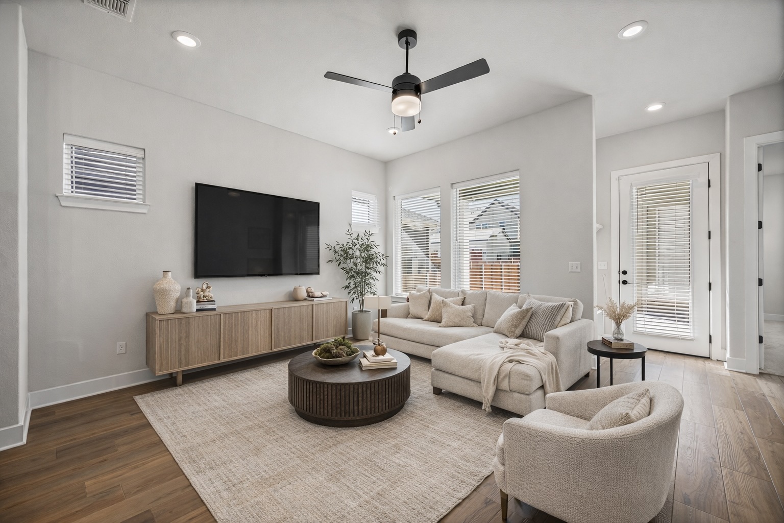 5806 Rangeland Road Austin, TX 78747 - Photo 3 of 34 Natural light pours into this living space, highlighting its warm wood flooring.