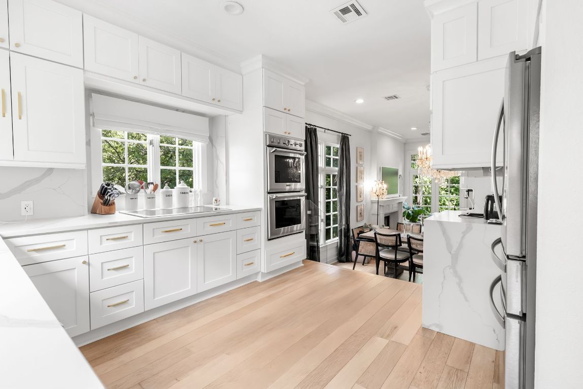 1937 Rue De St Tropez, Unit 10 Austin, TX 78746 - Photo 2 of 35 a kitchen with stainless steel appliances kitchen island granite countertop a refrigerator and cabinets