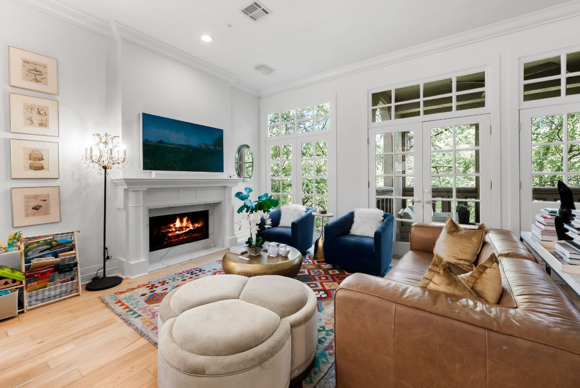 1937 Rue De St Tropez, Unit 10 Austin, TX 78746 - Photo 6 of 35 a living room with furniture a flat screen tv and a fireplace