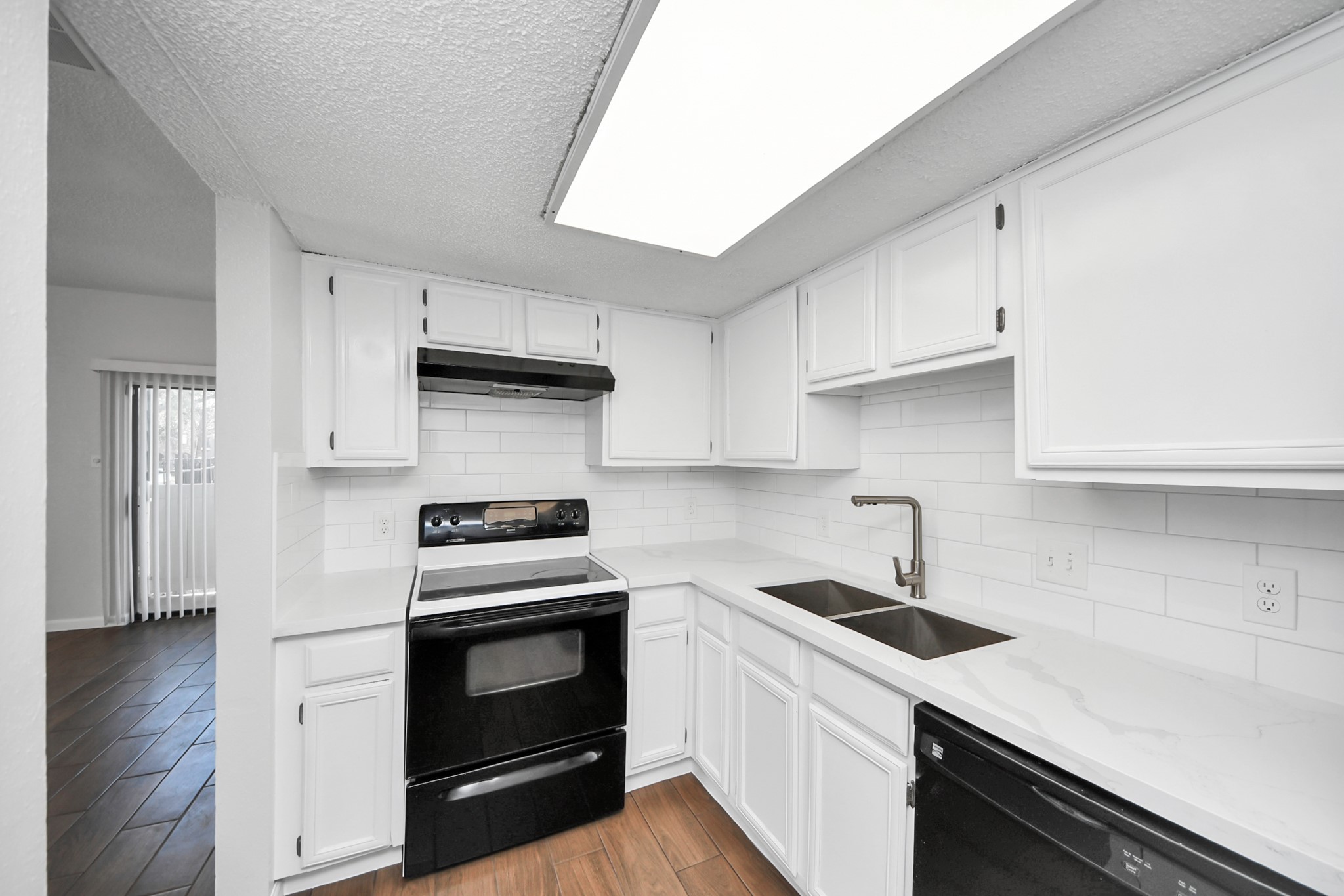 3750 Tanglewilde Street, Unit A7 Houston, TX 77063 - Photo 14 of 36 a kitchen with cabinets stainless steel appliances and wooden floor