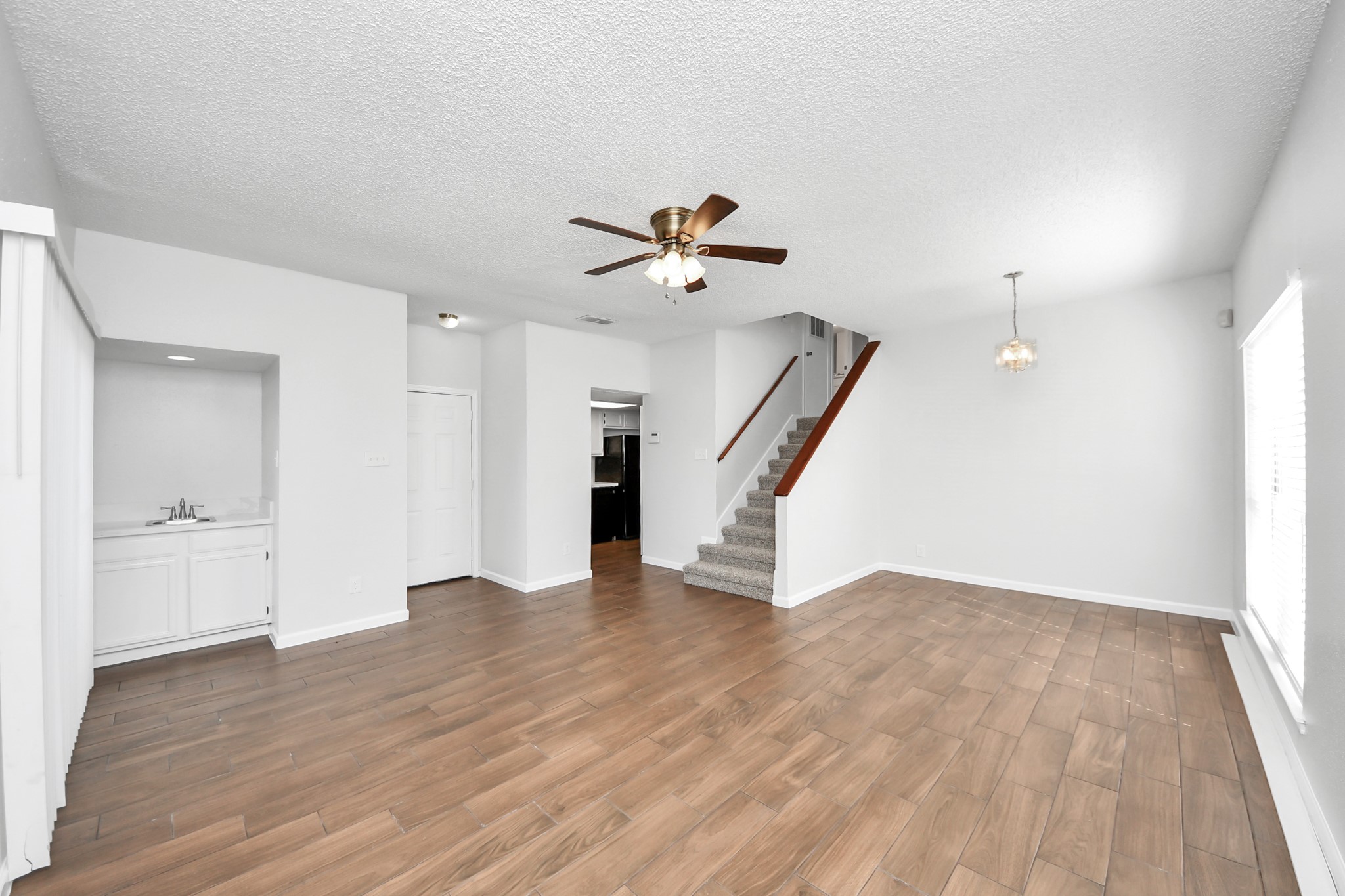 3750 Tanglewilde Street, Unit A7 Houston, TX 77063 - Photo 8 of 36 an empty room with wooden floor and a ceiling fan