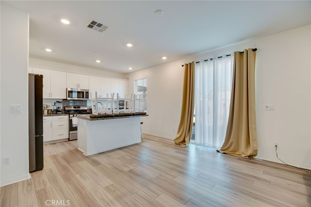 2526 Gunner Ridge Way Rialto, CA 92377 - Photo 12 of 33 a kitchen with stainless steel appliances granite countertop a refrigerator a sink and a stove