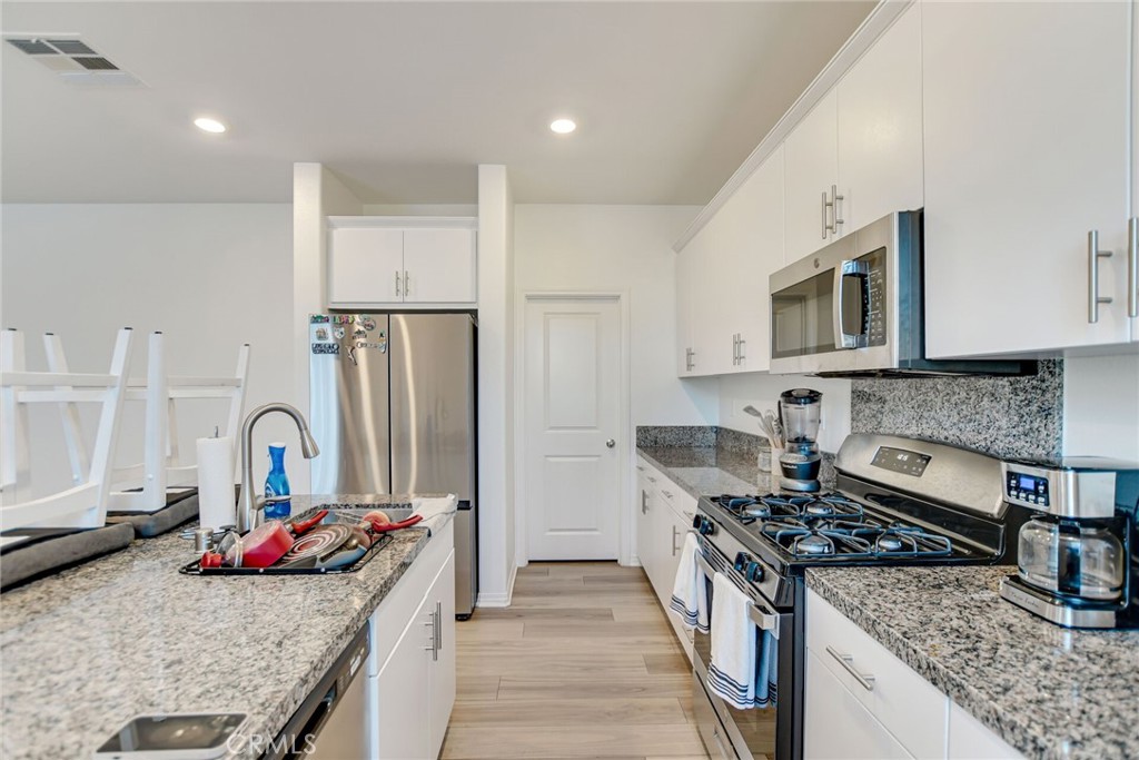 2526 Gunner Ridge Way Rialto, CA 92377 - Photo 16 of 33 a kitchen with stainless steel appliances granite countertop a stove and a sink