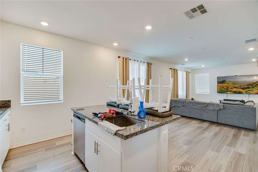 2526 Gunner Ridge Way Rialto, CA 92377 - Photo 18 of 33 a kitchen with stainless steel appliances granite countertop a sink stove and wooden floor