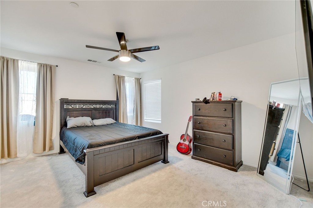 2526 Gunner Ridge Way Rialto, CA 92377 - Photo 20 of 33 a bedroom with a bed and a chandelier