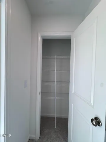 a view of a big room with windows and chandelier fan