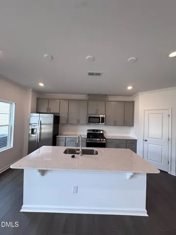a kitchen with refrigerator cabinets and wooden floor