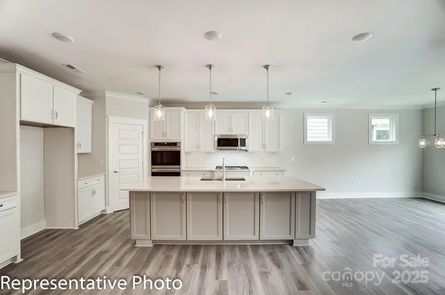 a kitchen with stainless steel appliances a white stove top oven and cabinets