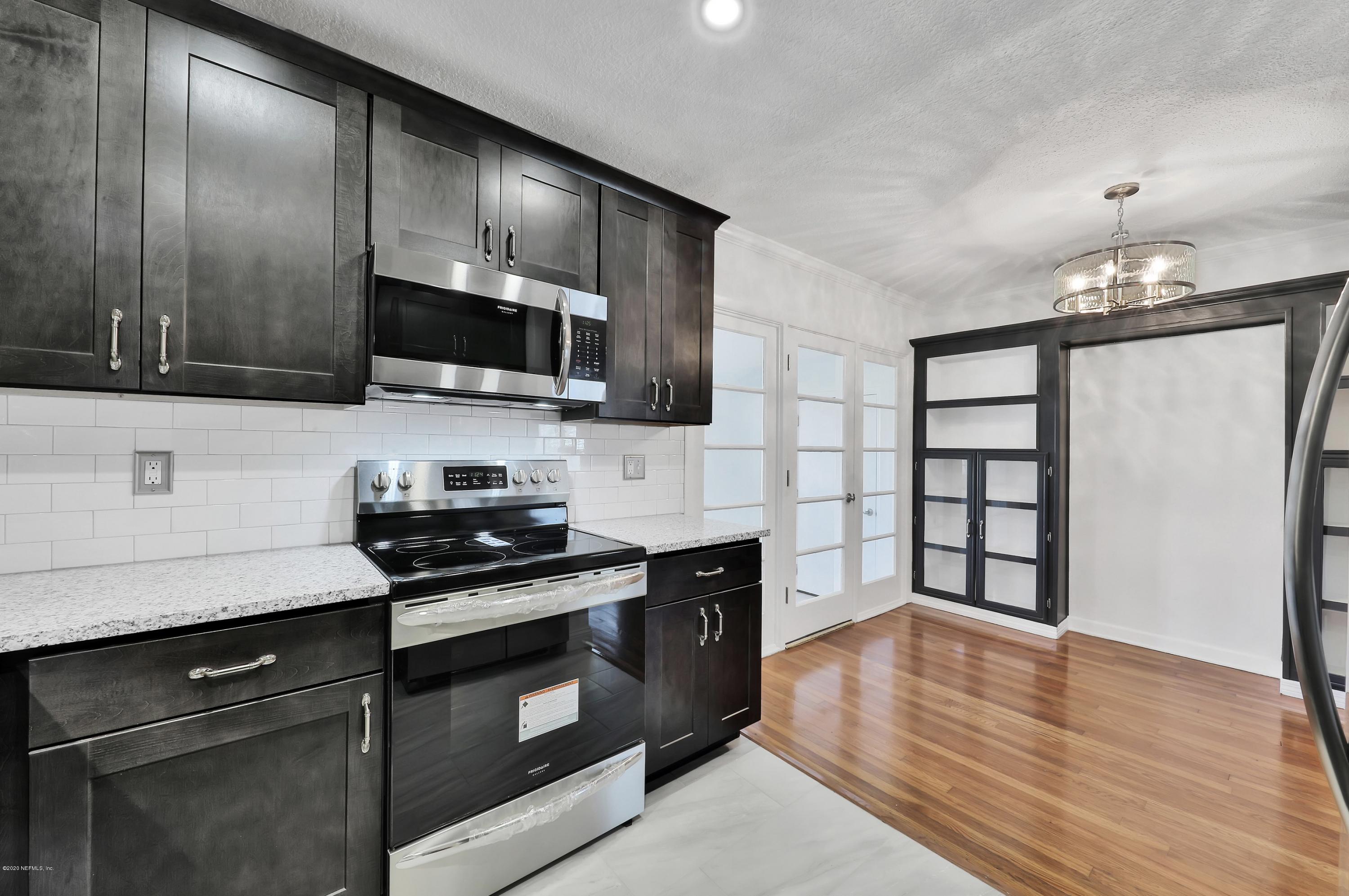 1705 Furman Road Jacksonville, FL 32217 - Photo 10 of 23 a kitchen with granite countertop a stove and a wooden floor