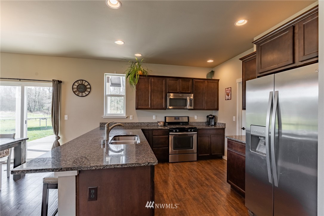 3223 Brown Road Ferndale, WA 98248 - Photo 6 of 40 a kitchen with granite countertop stainless steel appliances and wooden cabinets