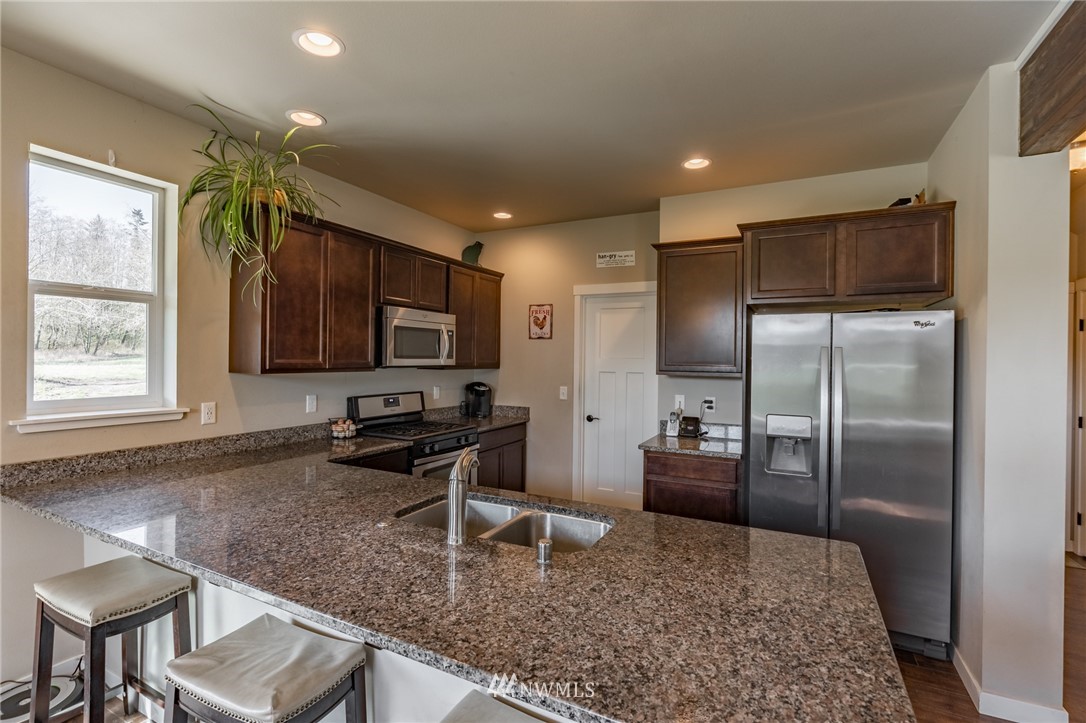 3223 Brown Road Ferndale, WA 98248 - Photo 7 of 40 a kitchen with kitchen island granite countertop a refrigerator stove and sink
