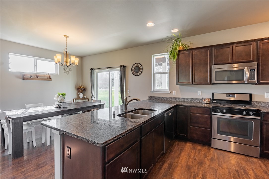 3223 Brown Road Ferndale, WA 98248 - Photo 8 of 40 a kitchen with granite countertop stainless steel appliances a stove sink microwave and cabinets
