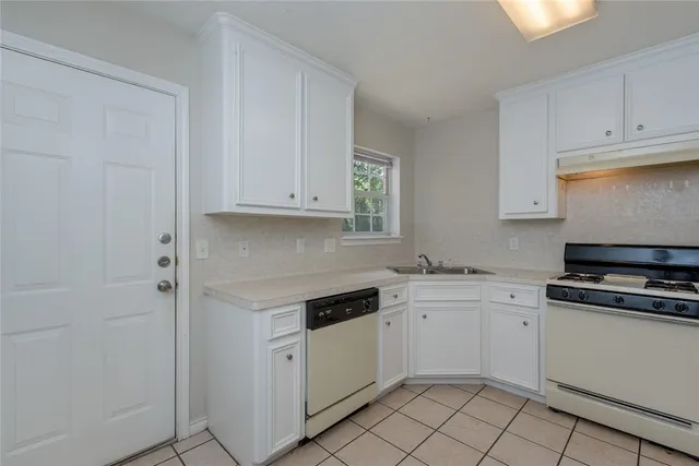 a kitchen with white cabinets and white appliances