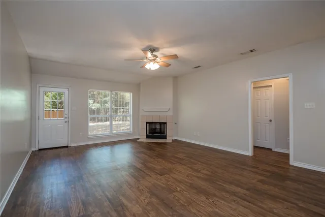 a view of a room with wooden floor and a ceiling fan