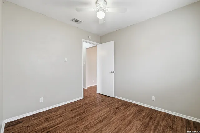 a view of an empty room with wooden floor
