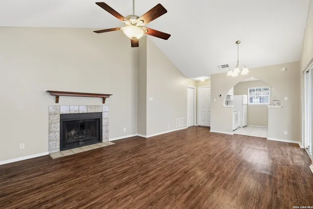 an empty room with fan and a fireplace
