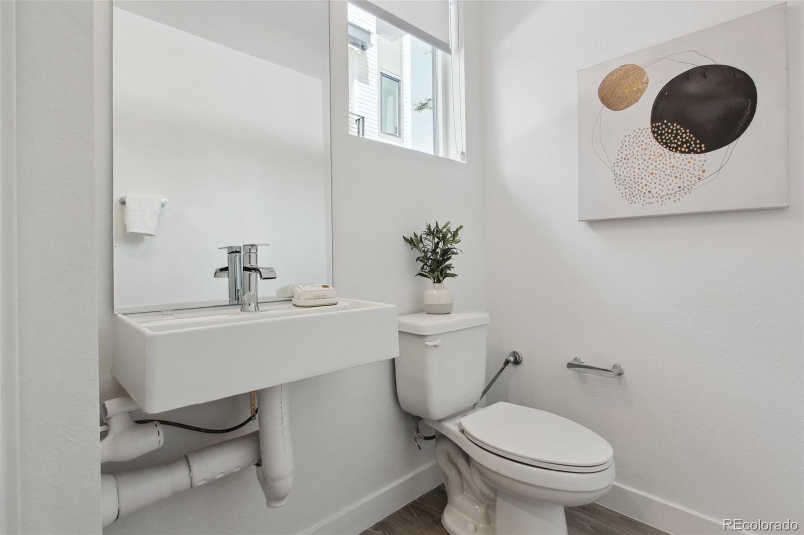 8705 Ralston Road Arvada, CO 80002 - Photo 11 of 16 a bathroom with a toilet sink and mirror