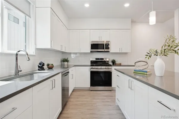 a kitchen with stainless steel appliances a sink a stove and cabinets