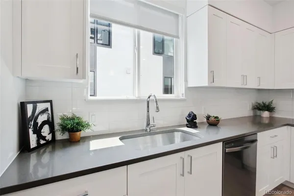a kitchen with stainless steel appliances white cabinets and a sink