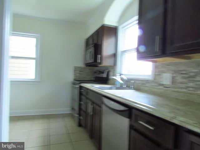 a kitchen with a sink cabinets and a window