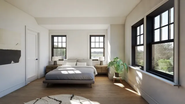 a spacious bedroom with a bed couch and windows