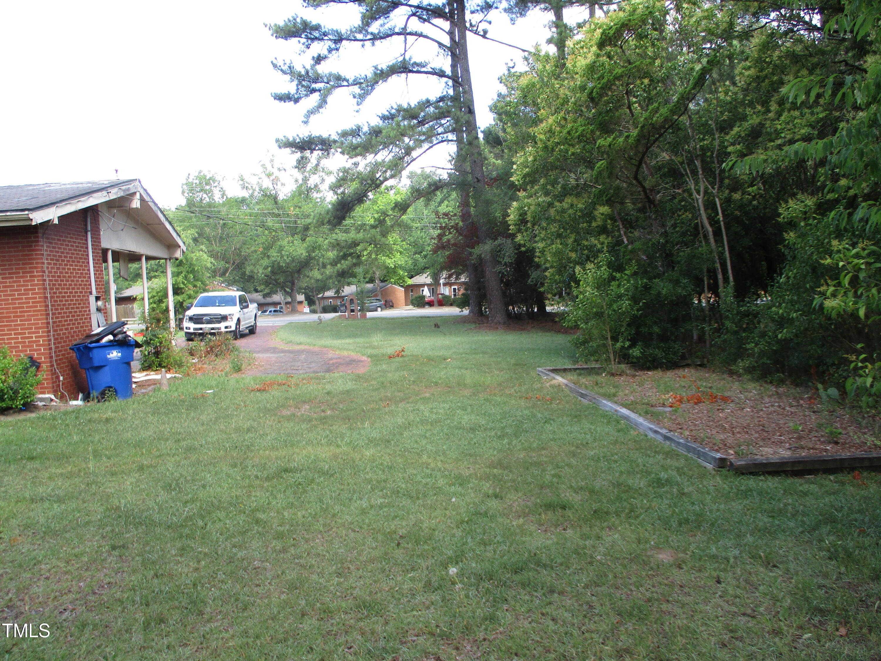 1432 Cross Link Road Raleigh, NC 27610 - Photo 10 of 16 a view of a yard with a house and a tree