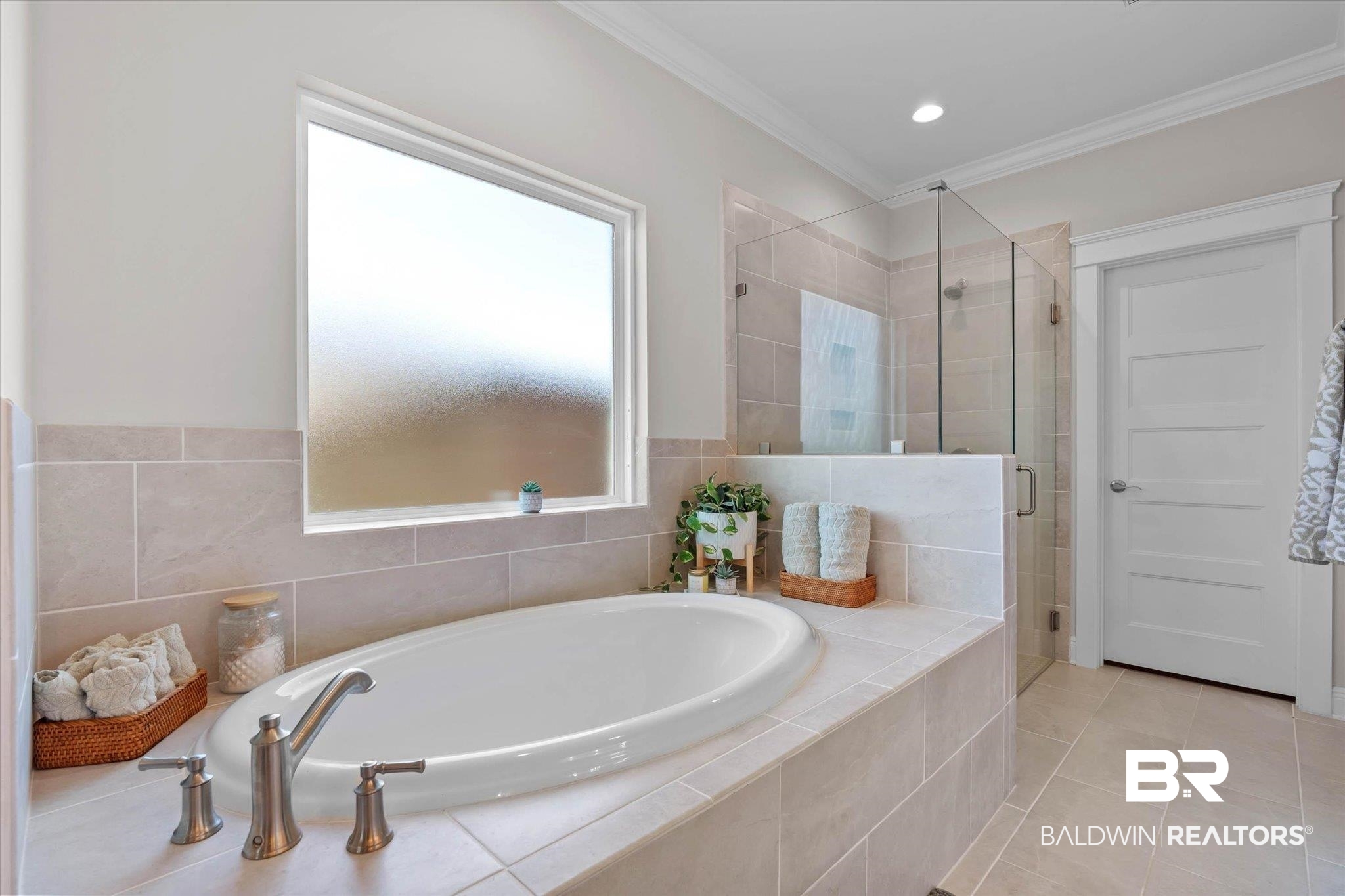 23523 Travis Stock Street Foley, AL 36535 - Photo 18 of 45 Soaking tub with brushed nickel fixtures, surrounded by light-toned tilework