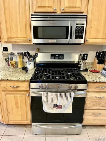 a kitchen with granite countertop cabinets and black appliances