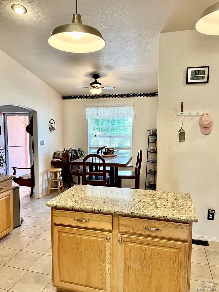 6053 Muddy Creek Road Pueblo, CO 81004 - Photo 19 of 50 a living room with stainless steel appliances kitchen island granite countertop furniture a rug and a large window
