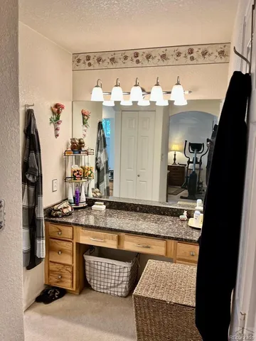 a bathroom with a granite countertop sink and a mirror