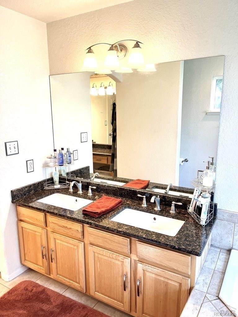 6053 Muddy Creek Road Pueblo, CO 81004 - Photo 25 of 50 a bathroom with a granite countertop sink and a mirror