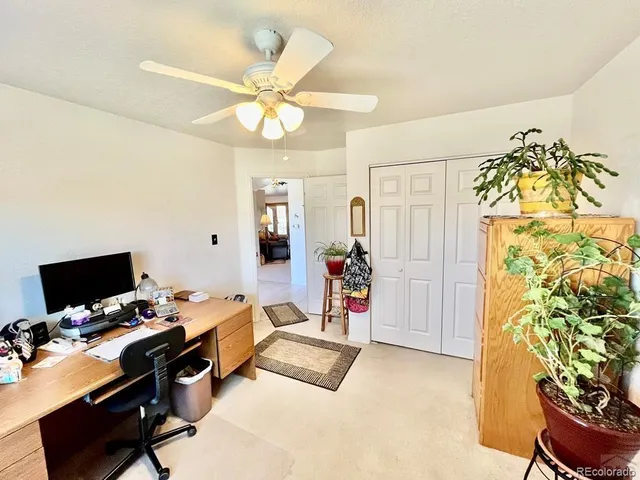 a view of a livingroom with workspace and a window
