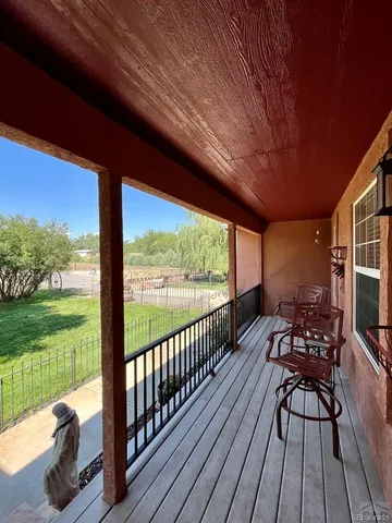 a view of a patio with wooden floor table and chairs
