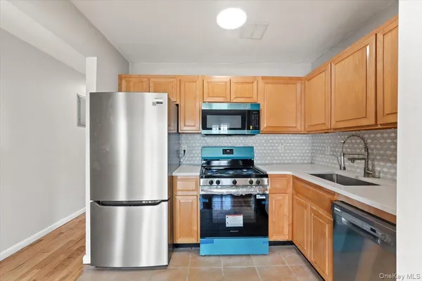 a kitchen with a refrigerator a stove top oven a sink and cabinets