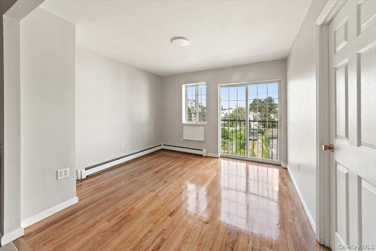 1309 Vreeland Avenue, Unit 3 Bronx, NY 10461 - Photo 5 of 13 Unfurnished room with baseboard heating, a baseboard radiator, and wood finished floors